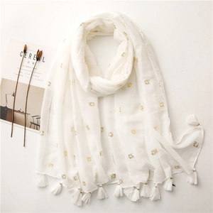 Detail view of beige scarf with gold foil tiger pattern and white fringe decorations