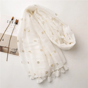 Detail of white cotton linen scarf with gold foil tiger pattern and beaded tassels