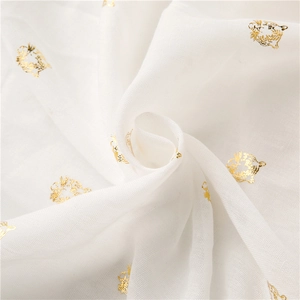 Detailed view of beige cotton linen scarf featuring gold foil tiger head pattern