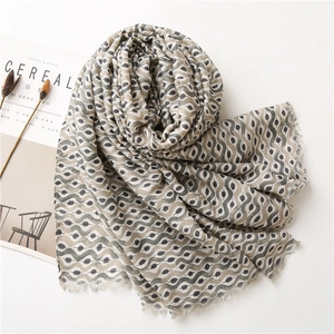 Close-up of wavy geometric pattern and fine fringe detail on a linen-feel scarf