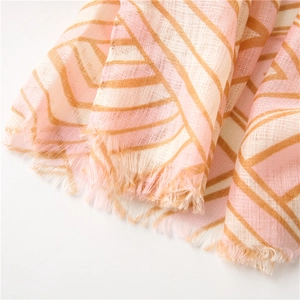 Close-up of geometric striped pattern on soft cotton linen scarf with frayed edges