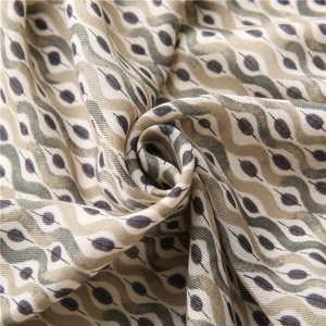 Detailed view of the wavy ripple print on a linen-feel cotton fabric scarf with green accents