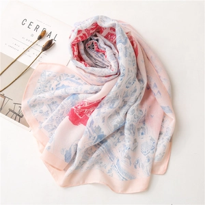 Écharpe rose avec motifs architecturaux bleus présentée sur fond blanc minimaliste