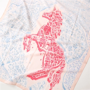 Gros plan du foulard en soie rose avec motif de cheval rouge et texture de carte bleue