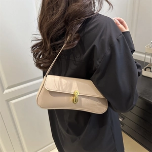 Chic beige patent leather underarm bag with a golden metal buckle and curved bottom