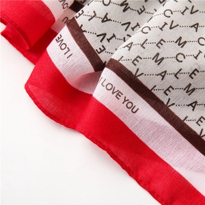 Détail de l'écharpe en soie avec texture sergée et imprimé lettres I LOVE YOU en rouge