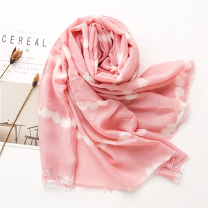 Detail of light pink cotton linen scarf featuring tie-dye patterns and fine fringe edges