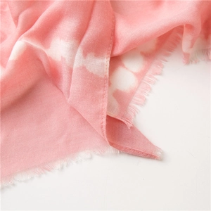 Detail of pink tie-dye cotton scarf featuring soft fabric texture and fringe edges