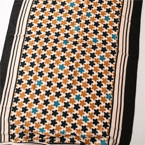 Close-up of floral print pattern on cotton linen scarf with elegant black border