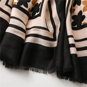 Detail of floral print scarf showing soft cotton linen fabric texture and fringe edges