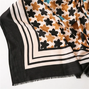Detailed view of floral linen scarf featuring delicate fringe edges and vibrant flower prints