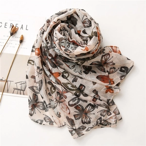 Detail shot of vintage butterfly print scarf with dried flowers and cereal magazine
