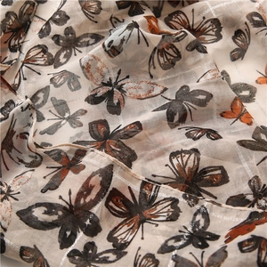 Close-up of silver glitter mesh fabric with butterfly print on a cotton linen scarf
