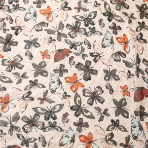Close-up of butterfly print fabric with silver thread grid texture on cotton scarf