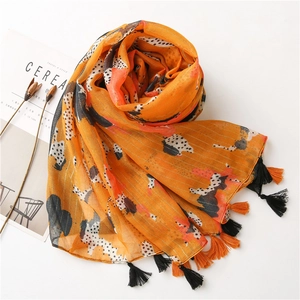 Detail of orange cotton linen scarf with black white polka dots and fringe edges