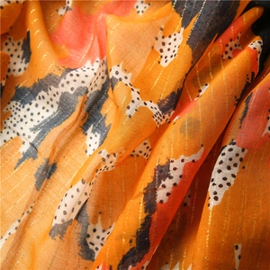 Detail of orange cotton-linen scarf showing gold lurex threads and polka dot pattern