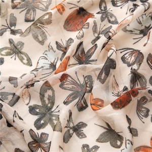 Close-up of butterfly print fabric with silver metallic threads and grid texture