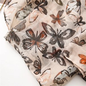Detail of butterfly print scarf with silver thread texture and rolled edge finish