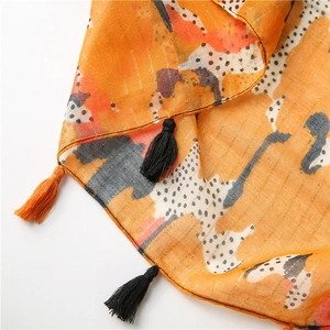 Detail of orange cotton-linen scarf with gold thread, abstract prints and fringe tassels