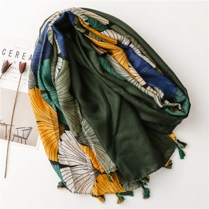 Detailed view of vintage ginkgo print cotton scarf with tassel edge on white background