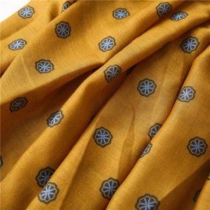 Macro detail of mustard yellow cotton linen fabric with blue vintage floral print