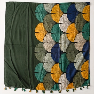 Detail of vintage ginkgo leaf print scarf with colorful tassel edges on cotton linen fabric