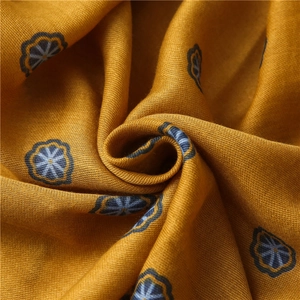 Macro shot of yellow bohemian cotton scarf fabric with geometric floral print