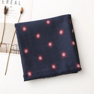 Detail of bohemian navy blue cotton linen shawl with red floral print and woven texture