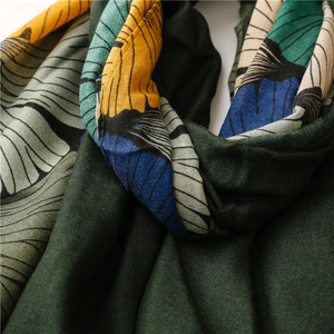 Macro shot of abstract ginkgo leaf patterns on a dark green cotton-linen blend scarf
