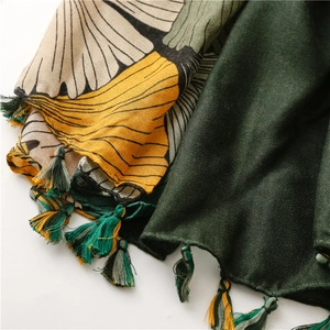 Detail of ginkgo leaf print scarf with multicolored tassels and fine woven texture