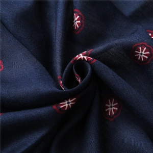 Detailed view of dark blue cotton linen fabric with vintage red and white floral patterns