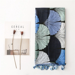 Detailed view of lightweight cotton-linen shawl with blue ginkgo leaf print and tassels