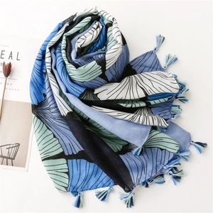 Macro detail of retro ginkgo leaf print scarf with elegant blue tassel trim accents