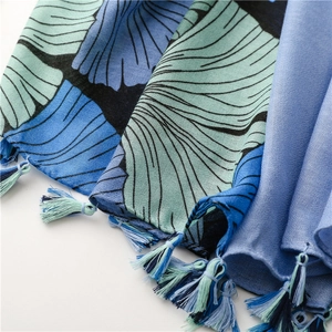 Detailed view of colorful tassels and gingko leaf print on cotton-linen feel scarf