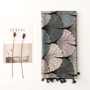 Detailed view of ginkgo leaf print scarf with elegant fringe and linen texture