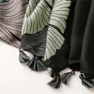 Detail of artistic ginkgo leaf print and colorful tassels on woven cotton linen shawl