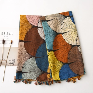 Detailed view of colorful ginkgo leaf print scarf with elegant fringe tassels on the edges