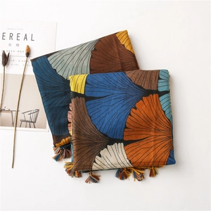 Detail of artistic gingko leaf print on cotton-linen scarf with colorful fringe tassels