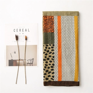 Détail d'une écharpe léopard avec motifs patchwork sur un tissu texturé de qualité