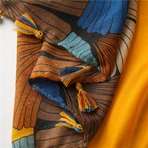 Detailed close-up of bird wing pattern fabric with colorful handmade tassel fringe