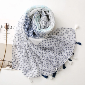 Detail of color-block floral scarf featuring blue paisley patterns and fringe tassels