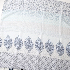 Detail of floral paisley pattern cotton linen shawl with delicate blue tassels