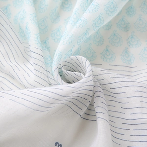 White cotton linen shawl with blue floral prints and stripes in a spiral display