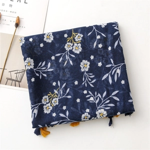 Detailed view of navy blue floral cotton linen scarf with bright yellow fringe tassels