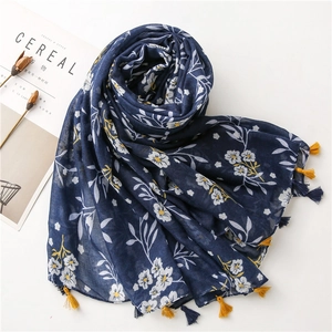 Detail of bohemian navy blue scarf with white floral print and yellow tassel fringe decor
