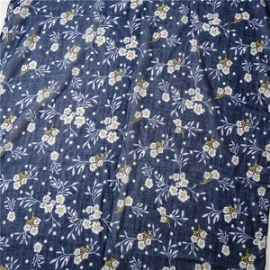 Close-up of navy blue linen cotton fabric with white floral patterns and soft texture