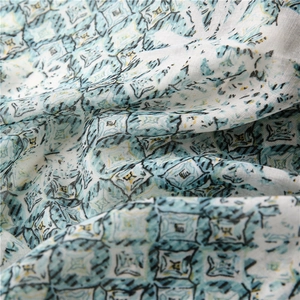 Close-up of lightweight cotton scarf showing teal geometric print and woven texture