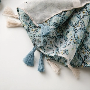 Detailed macro view of thin blue geometric scarf with soft tassels and breathable fabric