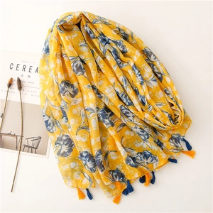 Lemon yellow cotton linen scarf with blue floral print and fringe tassels on white background
