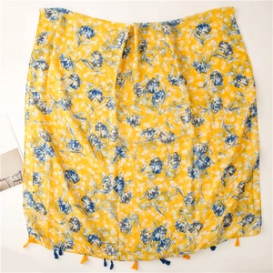 Close-up of lightweight lemon yellow cotton linen scarf with floral print and fringe
